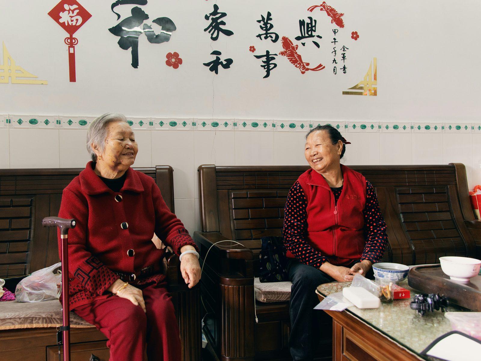 Two happy elderly women chatting at home, the kind of warm home setting home physiotherapy takes place in.